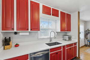 Kitchen featuring dishwasher and light stone counters
