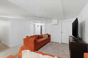Carpeted living room featuring baseboards