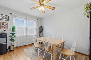 Dining space with light wood-style flooring and a ceiling fan