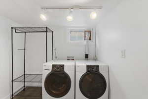 Washroom featuring washer and dryer and track lighting