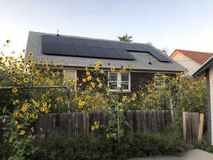 View of property exterior with solar panels and brick siding