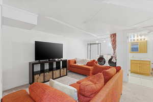 Living area with light colored carpet and washing machine and clothes dryer