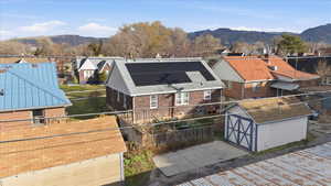 View of front of house featuring a mountain view, a shed, brick siding, and a residential view