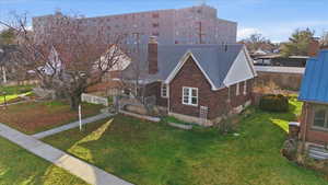 View of front of property with a chimney and brick siding