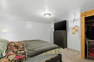 Bedroom with light carpet and baseboards