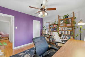 Office with wood finished floors and a ceiling fan