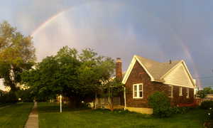 View of property exterior with a yard, a chimney, and roof with shingles