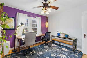 Home office with wood finished floors and a ceiling fan