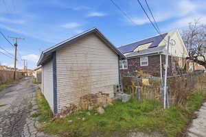 View of home's exterior featuring brick siding and a gate