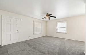 Spare room featuring carpet and a ceiling fan