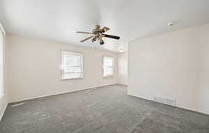 Carpeted spare room with baseboards and ceiling fan