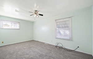 Spare room featuring carpet and ceiling fan