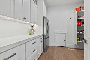 Laundry area featuring light wood finished floors and baseboards