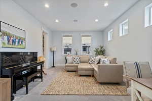 Living area with light carpet, plenty of natural light, and recessed lighting