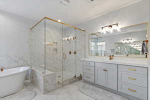 Full bathroom with a chandelier, a freestanding tub, vanity, a marble finish shower, and recessed lighting