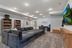 Living room featuring carpet floors, recessed lighting, and built in desk