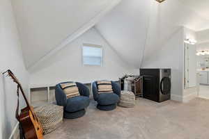 Living area featuring washer / clothes dryer, carpet floors, lofted ceiling, and a textured ceiling