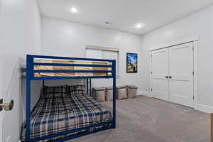 Bedroom with carpet floors, a closet, and recessed lighting