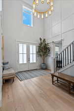 Entryway featuring french doors, stairs, healthy amount of natural light, and a towering ceiling