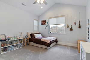 Bedroom with vaulted ceiling, carpet floors, and ceiling fan
