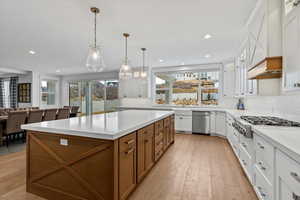 Kitchen featuring brown cabinets, hanging light fixtures, open floor plan, decorative backsplash, and recessed lighting