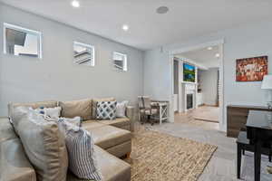 Living room with carpet floors, recessed lighting, and a glass covered fireplace