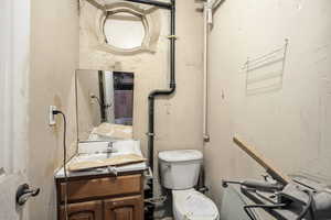 Half bathroom with vanity and a textured wall