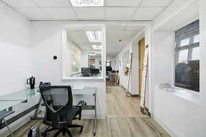 Office area featuring a drop ceiling and light wood finished floors