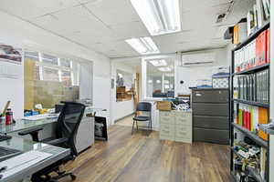 Office area featuring a drop ceiling and an AC wall unit