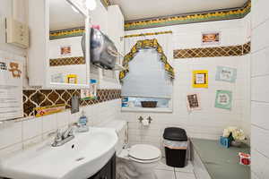 Bathroom with vanity, tile patterned flooring, and tile walls