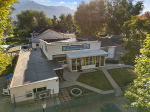 View of front of property with a sunroom, a mountain view, a gate, and a patio