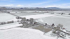 Snowy aerial view featuring a view of rural / pastoral area and a mountain view