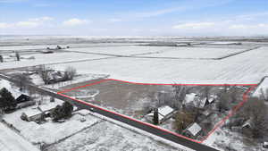 Snowy aerial view featuring a view of countryside and property parcel outlined