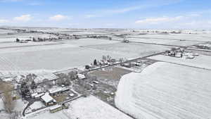 Aerial view of property and surrounding area with rows of crops and rural landscape