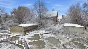 Snow covered property featuring an outdoor structure and stairs
