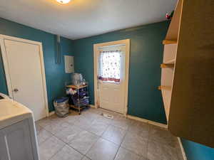 Entryway featuring light tile patterned flooring and electric panel