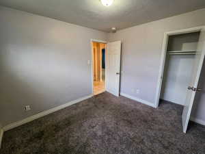 Unfurnished bedroom with a closet and carpet floors