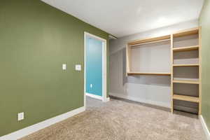 Unfurnished bedroom featuring light carpet and a closet