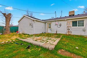 Rear view of property featuring a lawn and a patio