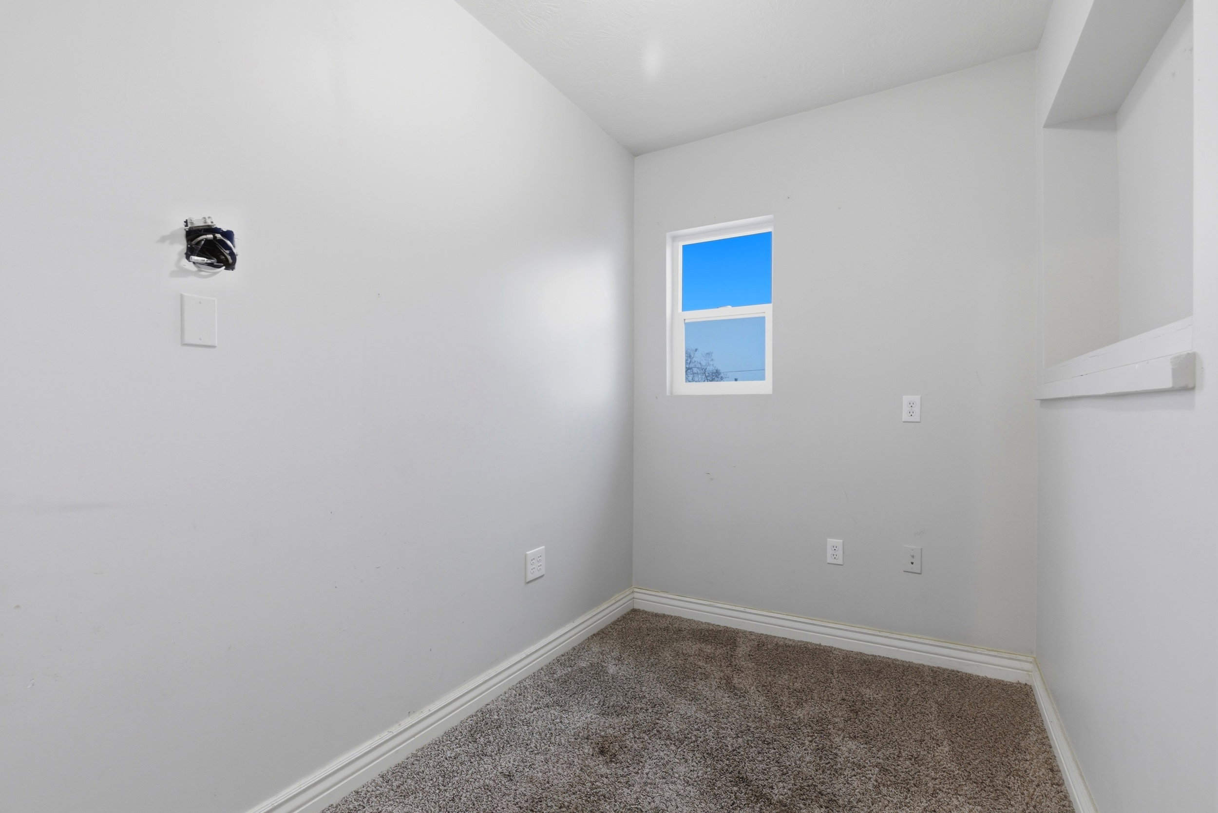 Carpeted spare room featuring baseboards