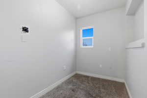 Carpeted spare room featuring baseboards
