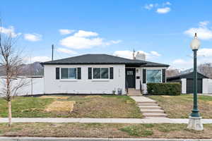 Bungalow-style house featuring a front lawn, brick siding, and a chimney