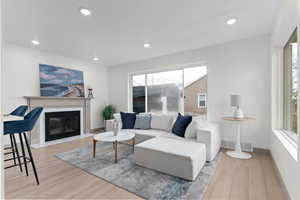 Living area featuring light wood-type flooring, a fireplace with flush hearth, and recessed lighting