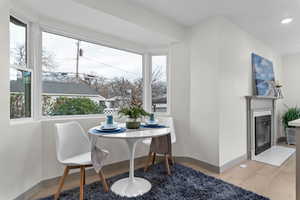 Dining space featuring a fireplace with flush hearth, recessed lighting, and light wood-style flooring
