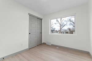 Unfurnished bedroom with a closet and light wood finished floors