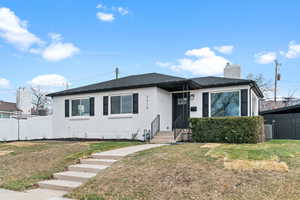 Bungalow-style home with a chimney and brick siding