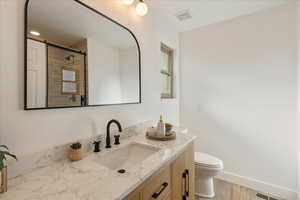 Bathroom featuring vanity, a shower stall, light wood finished floors, and recessed lighting