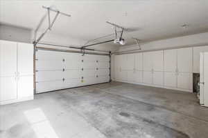 Garage featuring freestanding refrigerator and a garage door opener