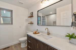 Full bathroom featuring light wood finished floors, vanity, and curtained shower