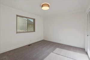 Carpeted spare room with baseboards and ornamental molding